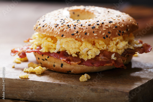 Breakfast sandwich with bagel, scrambled eggs, bacon and cheese