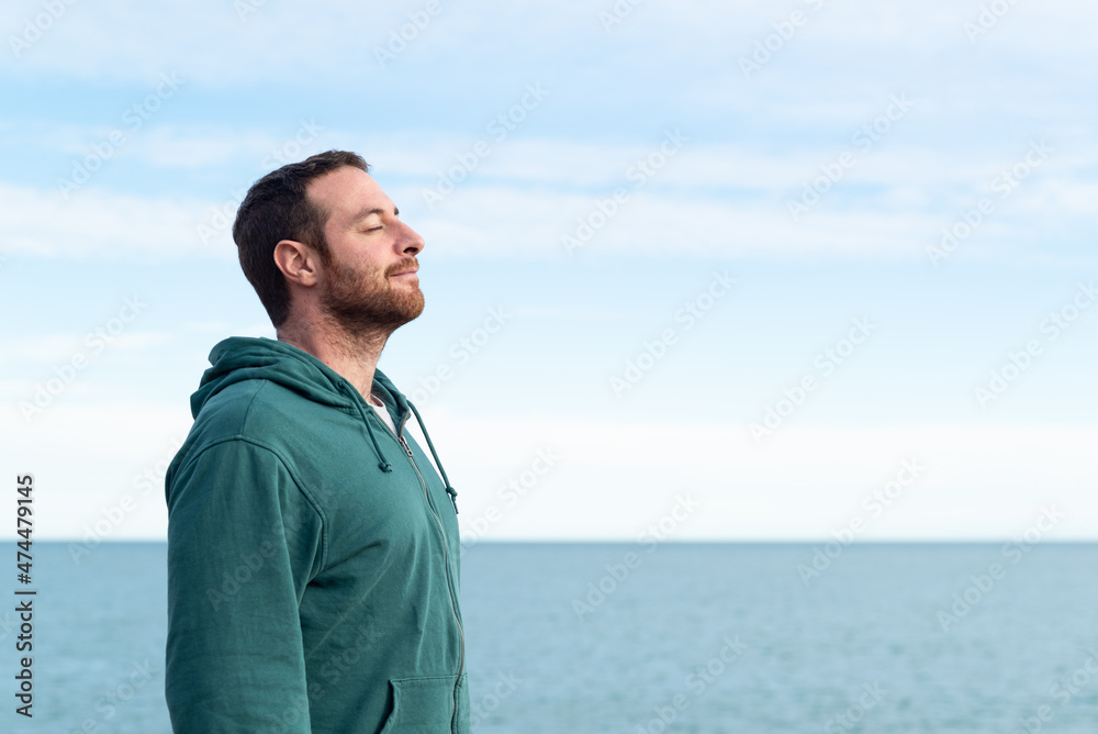 Relaxed man breathing fresh air with the sea at the background. Relaxed man breathing fresh air with the sea at the background.