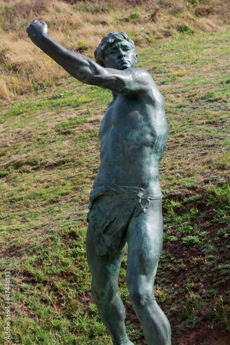 Old bronze statue of a young Greek