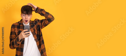 isolated teenager boy surprised looking at mobile phone