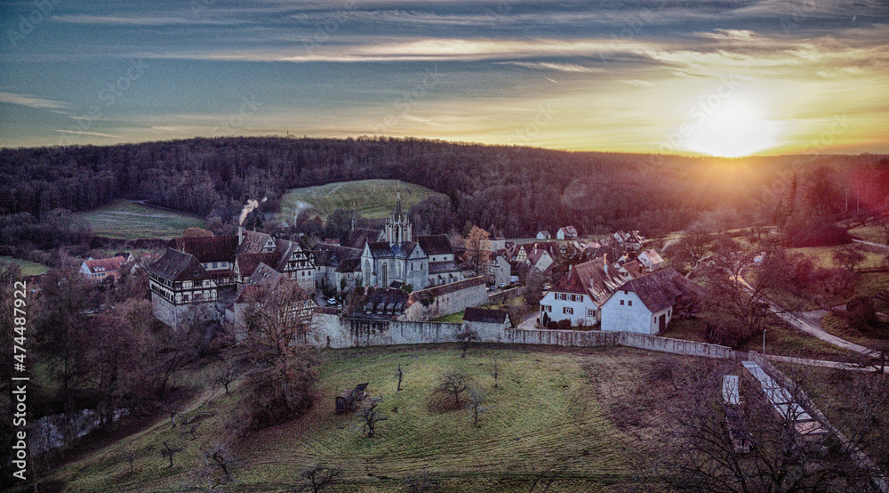 Kleines Dorf mit Klosteranlage im Sonnenuntergang aus der Luft aufgenommen