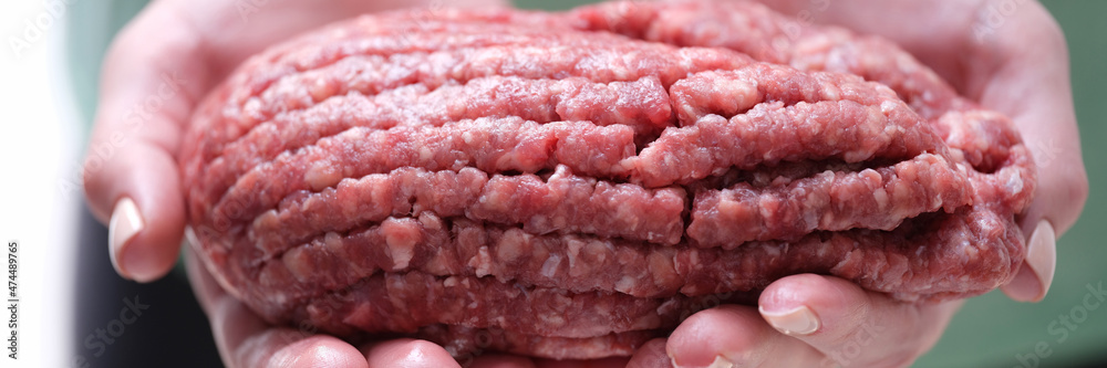 Female hands holding minced beef meat closeup Female hands holding minced beef meat closeup