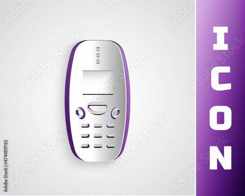Paper cut Old vintage keypad mobile phone icon isolated on grey background. Retro cellphone device. Vintage 90s mobile phone. Paper art style. Vector