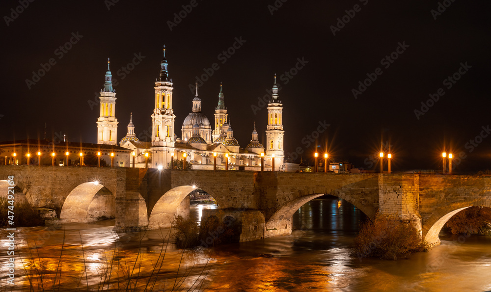 Long exposure at night on the Puente de Piedra next to the Basilica of Nuestra Señora del Pilar on the Ebro river in the city of Zaragoza, Aragon. Spain Long exposure at night on the Puente de Piedra next to the Basilica of Nuestra Señora del Pilar on the Ebro river in the city of Zaragoza, Aragon. Spain