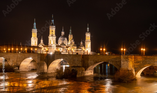 Long exposure at night on the Puente de Piedra next to the Basilica of Nuestra Señora del Pilar on the Ebro river in the city of Zaragoza, Aragon. Spain