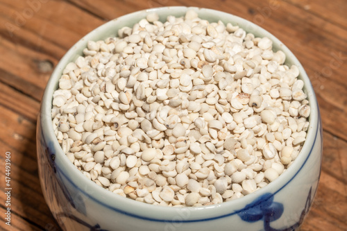 The plate or bowl on the wood grain table contains job's tears