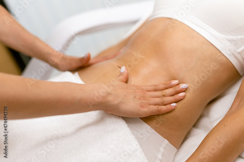 Middle-aged woman having a belly massage in a beauty salon.