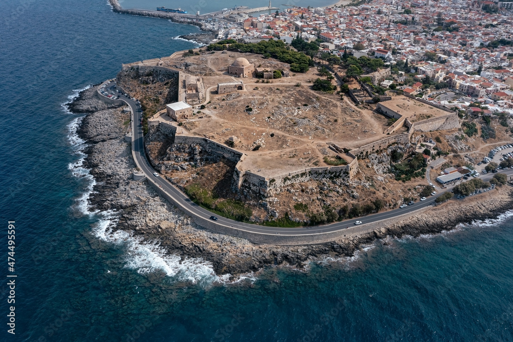 Medieval Venetian castle Fortezza ruins on rock surrounded by modern urban areas, Rethymno, Greece