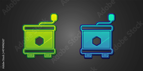Green and blue Honey extractor icon isolated on black background. Mechanical device for honey extraction from honeycombs. Vector