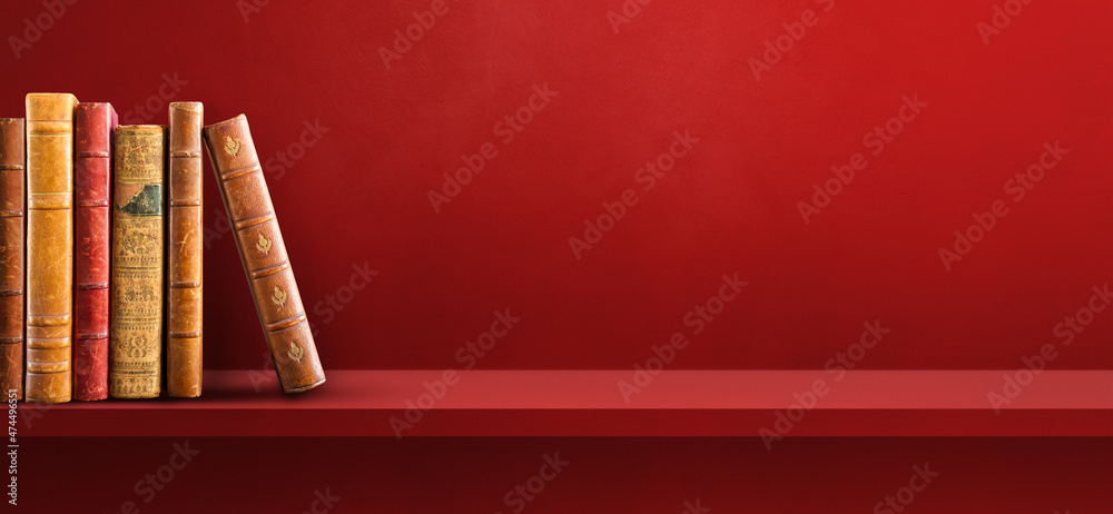 Row of old books on red shelf. Background banner Row of old books on red shelf. Background banner