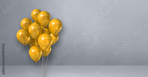 Yellow balloons bunch on a grey wall background. Horizontal banner.