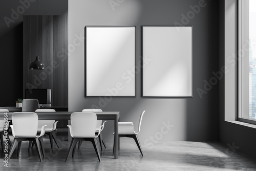 Dark office room interior with two empty white posters, desktops