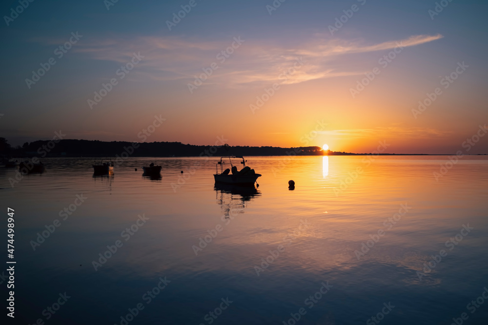 View of the fishing boats on the river during an amazing sunset.
