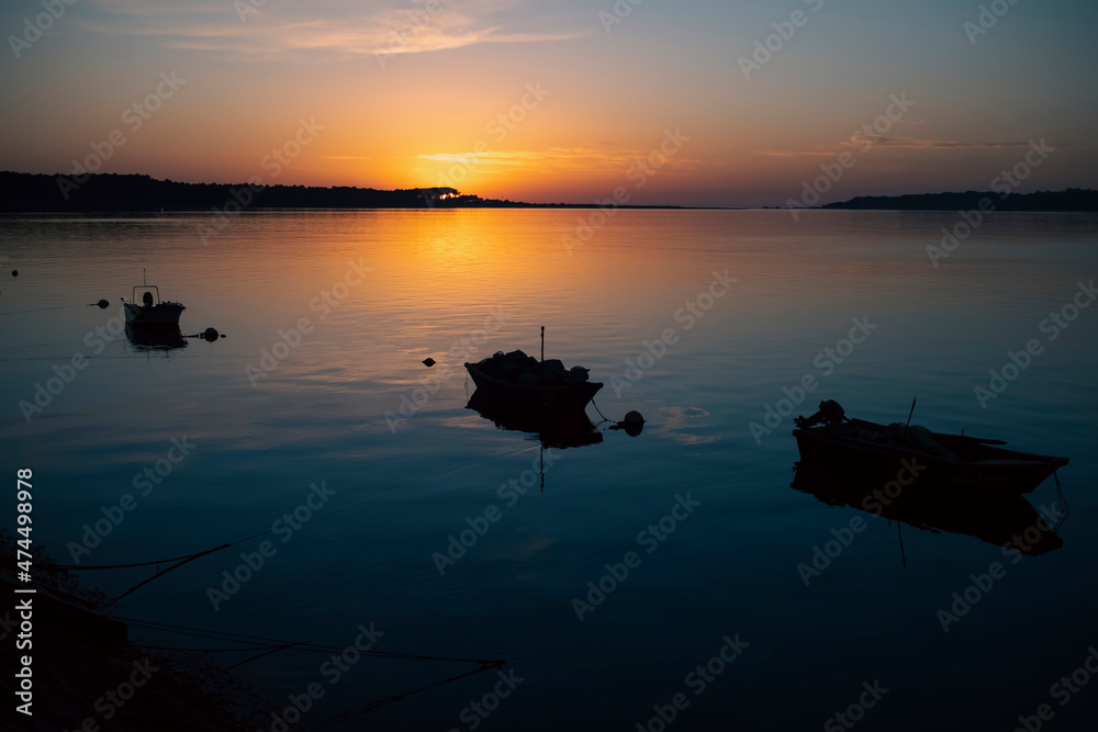 View of the Minho River at amazing sunset, silhouettes of fishing boats on the border between Portugal and Spain.