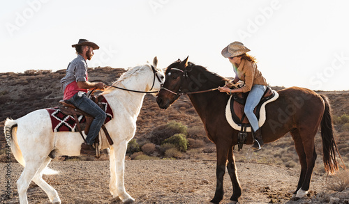 Farmers having fun riding a horses inside corral ranch