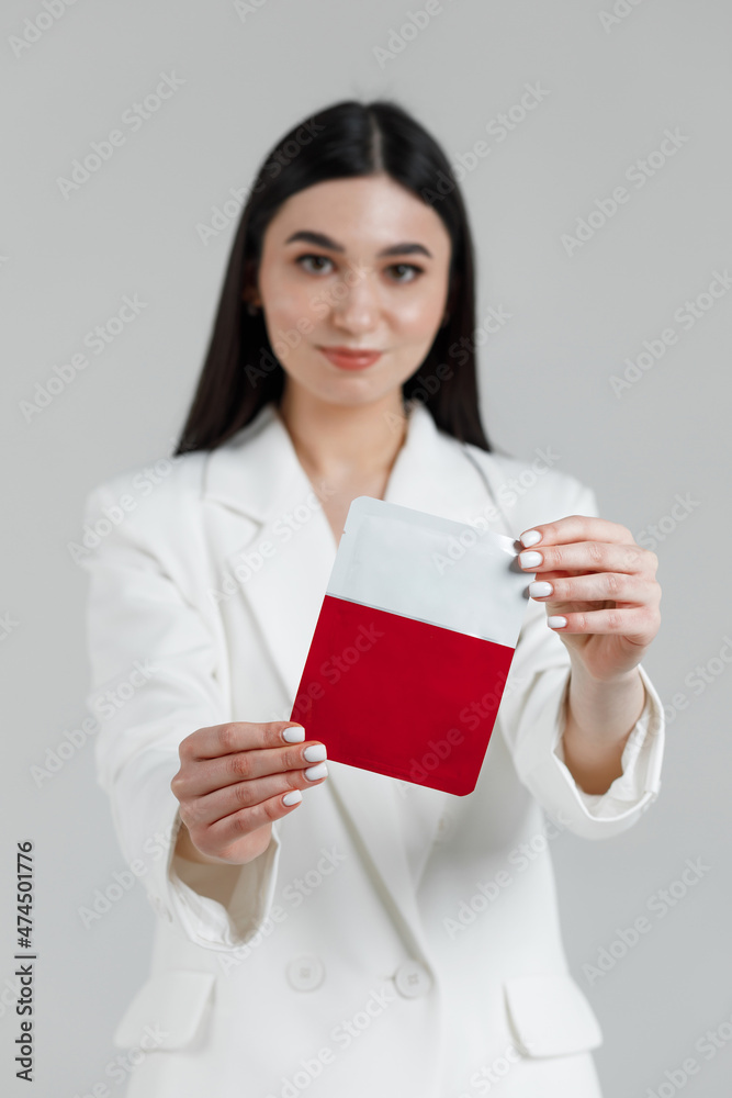 Smiling good looking cosmetologist holding a pack with face mask in her hands Smiling good looking cosmetologist holding a pack with face mask in her hands