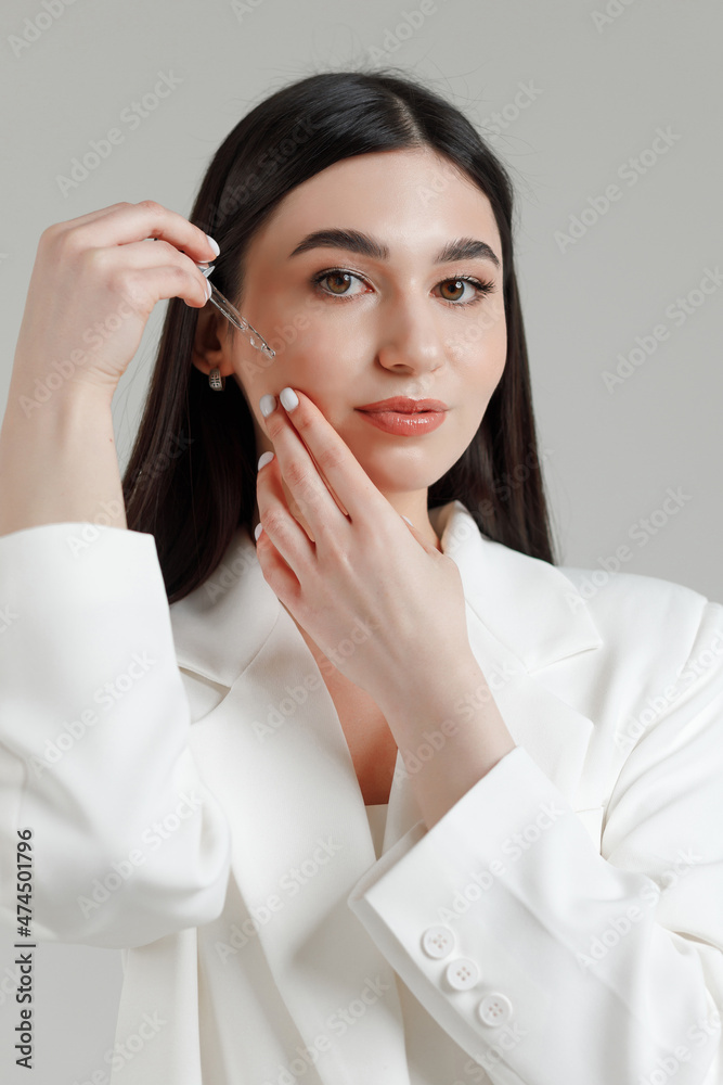 Cosmetologist and model putting micellar water on her face with pipette