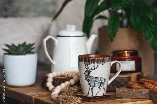 Lifestyle. A cup of tea with a deer on a wooden table during the Christmas holidays. Still-life. The concept of home warmth, comfort.