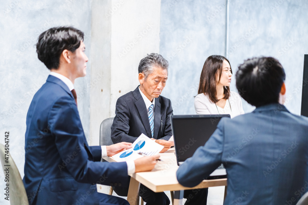 商品企画のプレゼンテーションを聞くビジネスパーソン 商品企画のプレゼンテーションを聞くビジネスパーソン