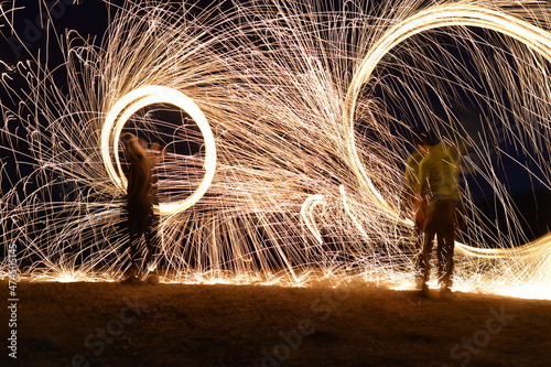 Iron wool circle drawing light fireworks. Burning Steel Wool spinning, Trajectories of burning sparks at night. Movement light effect, steel wool fire hoop. long exposure light painting, Pyrotechnic