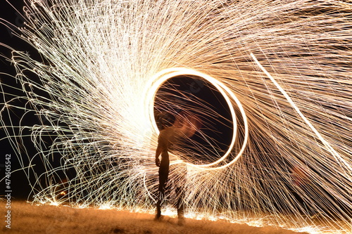 Iron wool circle drawing light fireworks. Burning Steel Wool spinning, Trajectories of burning sparks at night. Movement light effect, steel wool fire hoop. long exposure light painting, Pyrotechnic