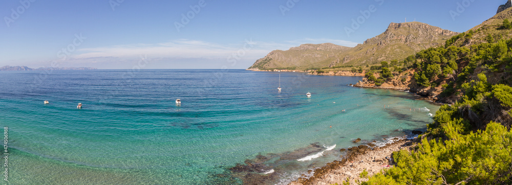 Turquoise water, rocky coast line and boats at beautiful beach Cala na clara near Betlém at Mallorca island, Mediterranean Sea, Spain (Panorama)