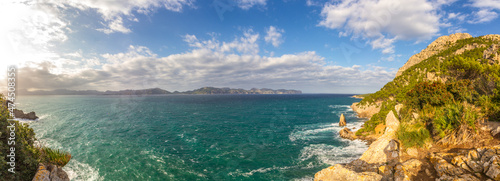 Fototapeta Naklejka Na Ścianę i Meble -  Coast of the Mediterranean Sea at Alcúdia peninsula with clouds and blue sky, Mallorca island, Balearic islands, Spain, Europe (Panorama)