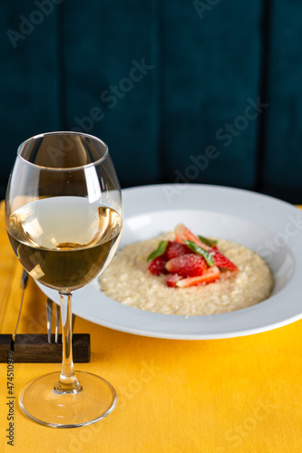 glass of wine and risotto with strawberries in the restaurant