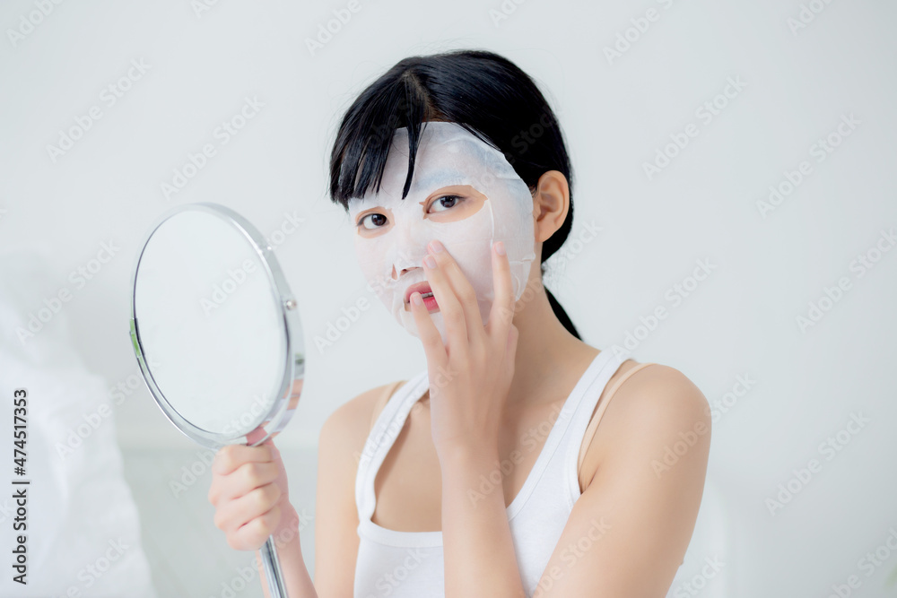 Beautiful young asian woman with sheet facial mask and looking mirror at home, beauty girl applying cosmetic and makeup and touch face with skin care for wrinkle, skincare treatment and moisturizer. Beautiful young asian woman with sheet facial mask and looking mirror at home, beauty girl applying cosmetic and makeup and touch face with skin care for wrinkle, skincare treatment and moisturizer.