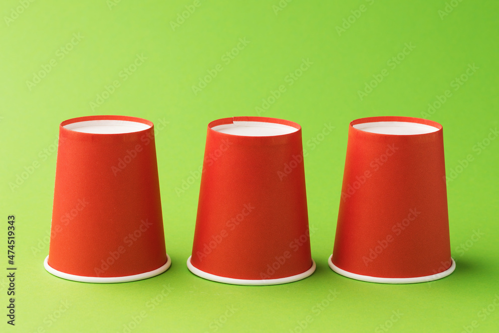 Inverted red paper cups on a green background Inverted red paper cups on a green background