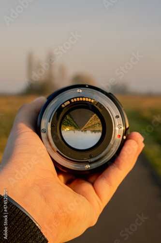 camera lens held by hand infront of street landscape