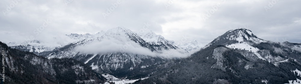 Amazing mystical rising fog forest snow snowy trees landscape snowscape in the mountains winter, Germany Allgäu panorama banner - dark mood in the alpine alps..