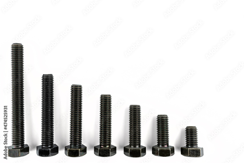 Background made of black screws with a hardness of 4.8, isolated on a white background, visible small and large screws. Background made of black screws with a hardness of 4.8, isolated on a white background, visible small and large screws.