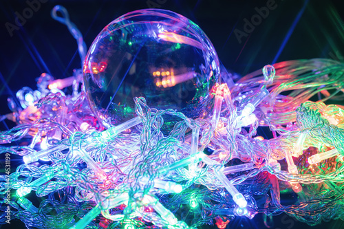 Large glass ball surrounded by glowing garland bulbs
