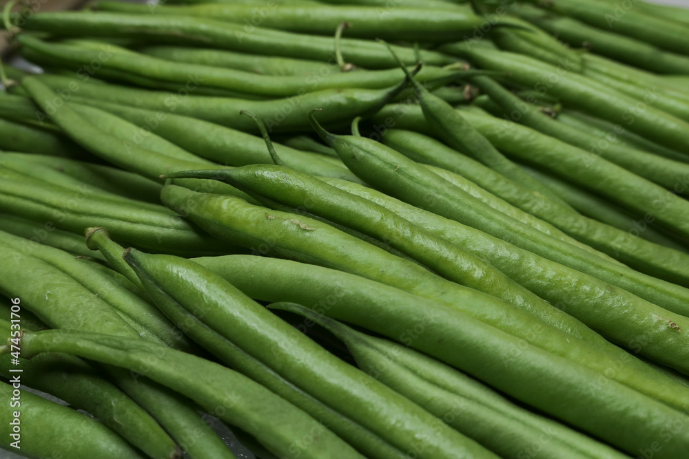Close-up of fresh green beans lined up. Immature pods of common beans. Vegetable for vegetarian. Food for vegan. Close-up of fresh green beans lined up. Immature pods of common beans. Vegetable for vegetarian. Food for vegan.