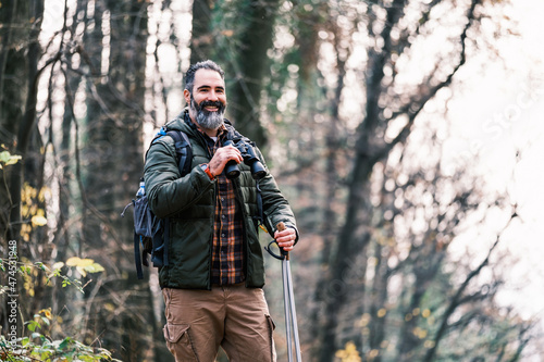 Image of man hiking and using binoculars.