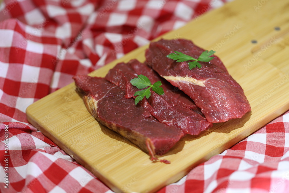 Meat varieties presented with fresh vegetables in plastic plates.