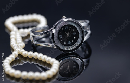 Women's watch in the original metal case and a pearl necklace