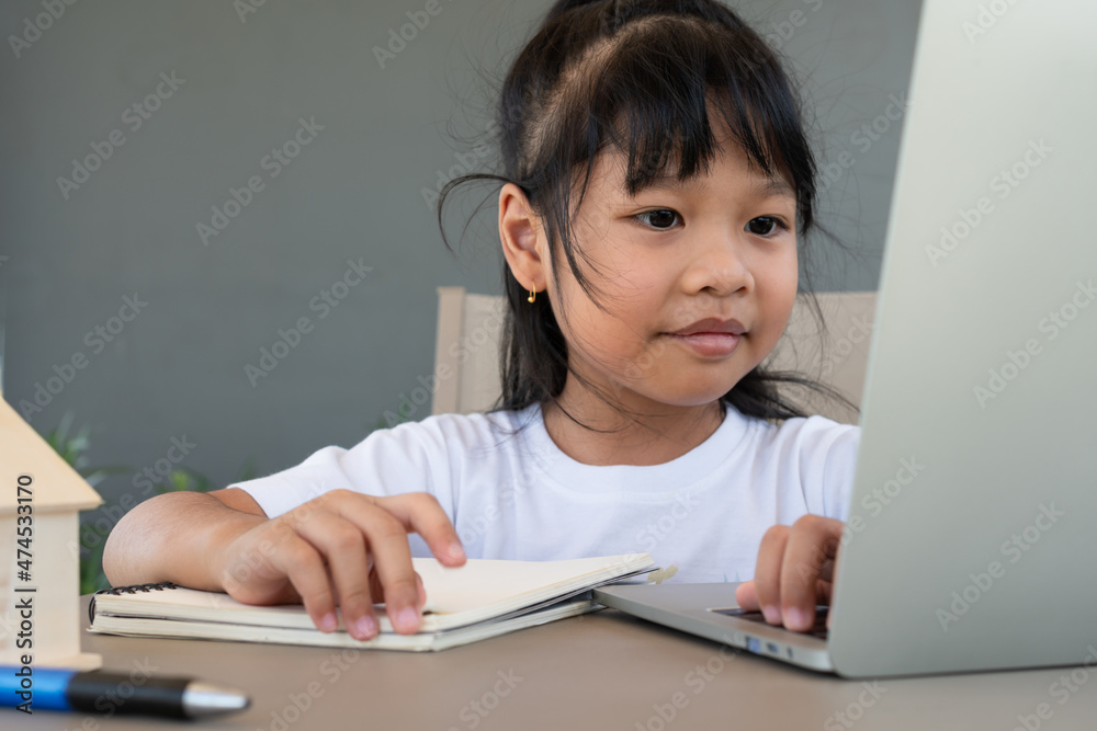 Asian girl student using the laptop for online learning class and doing homework at home, Education and distance learning for children Homeschooling concept Asian girl student using the laptop for online learning class and doing homework at home, Education and distance learning for children Homeschooling concept