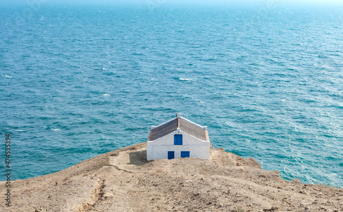 Simple house on the edge of a cliff overlooking the sea