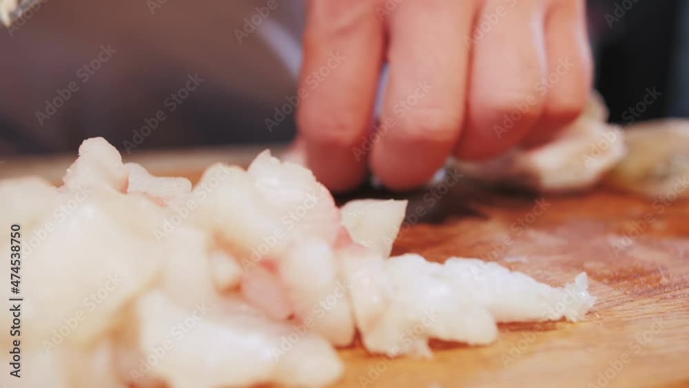 fish fillet is cut with a knife on a kitchen board fish fillet is cut with a knife on a kitchen board