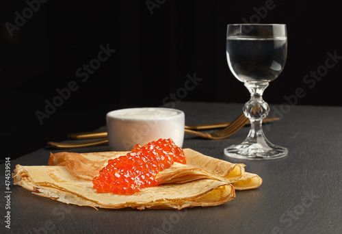 Golden russian pancakes with red caviar. Traditional Maslenitsa food. Christmas and New Year celebration. photo