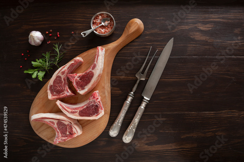 Fresh raw lamb on ribs on dark wooden background