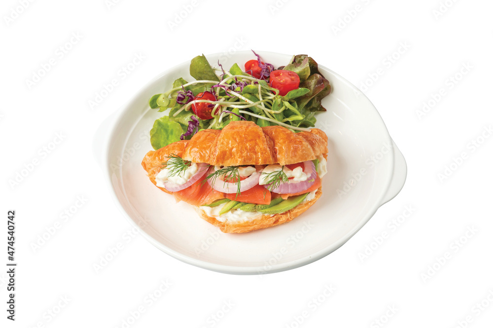 Croissant sandwich with salmon on white plate, served with fresh salad leaves. Croissant sandwich with salmon on white plate, served with fresh salad leaves.