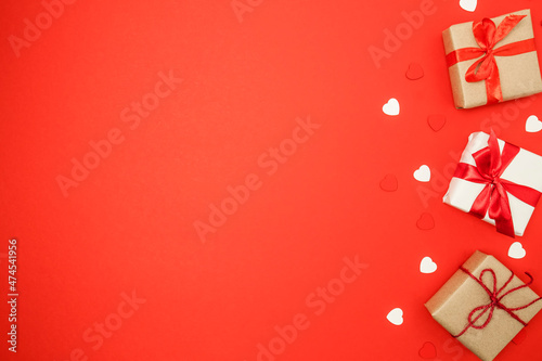 Gift boxes and hearts on red background. Valentine's day concept. Top view, copy space