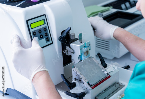 Laboratory assistant works on a rotary microtome section and making microscope slides