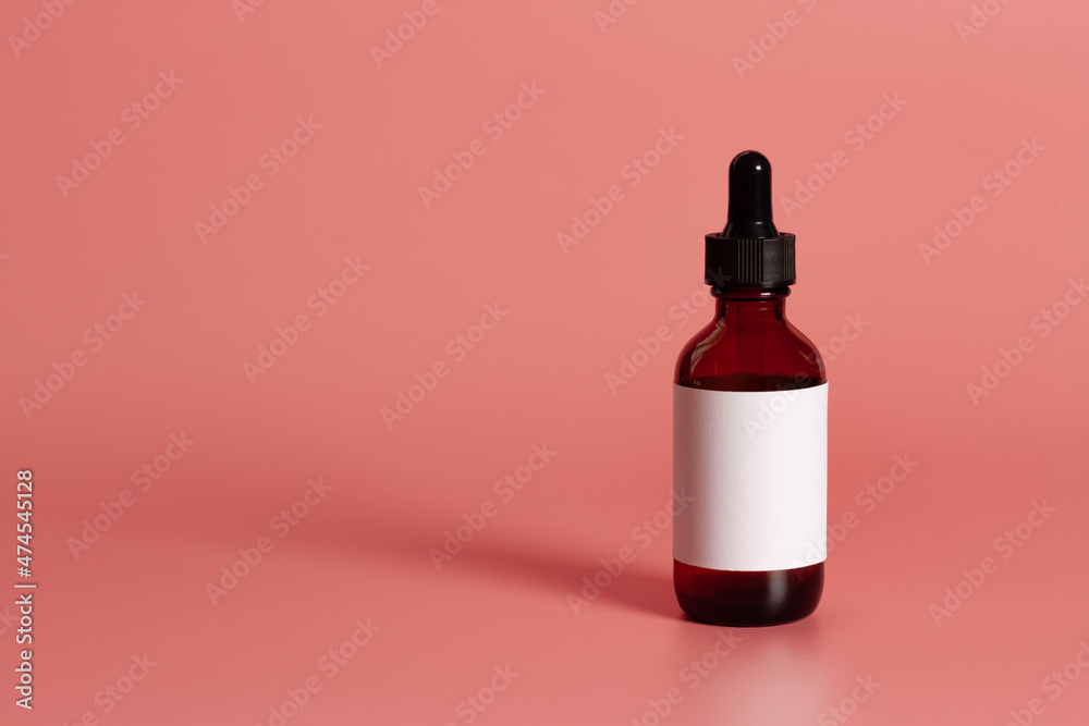 Dropper bottle with blank label mock-Up on pink background.