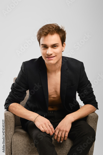 Young man in black suit siting in an armchair © boomeart