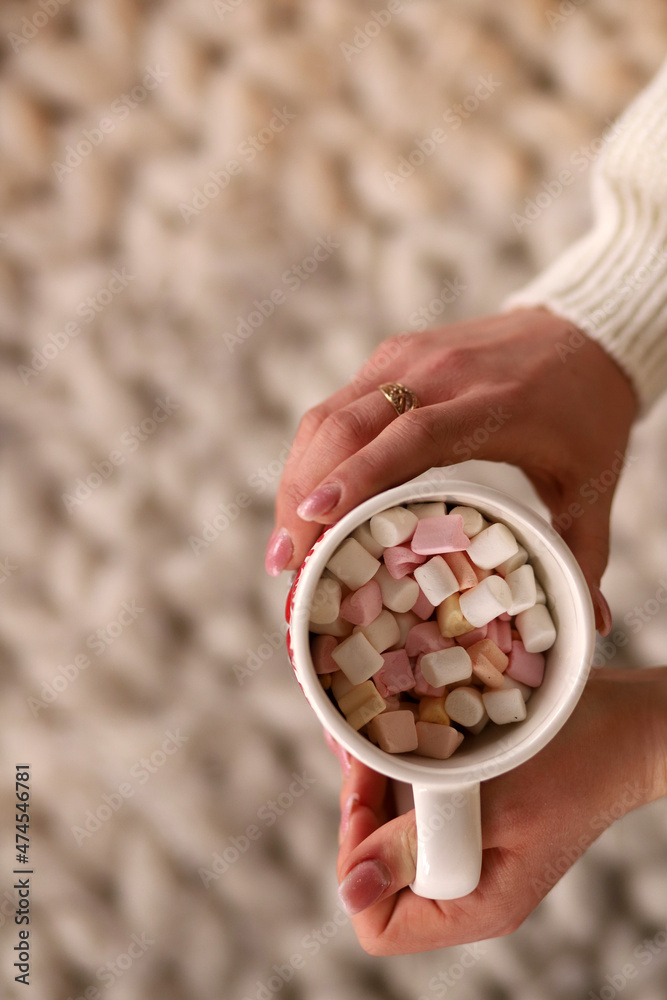 Female hand holding cup of marshmallow. Vertical orientation Female hand holding cup of marshmallow. Vertical orientation