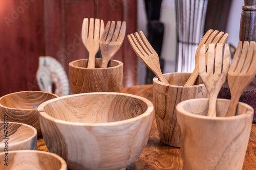 Wooden tableware, with natural wood bowls, glasses and forks. 